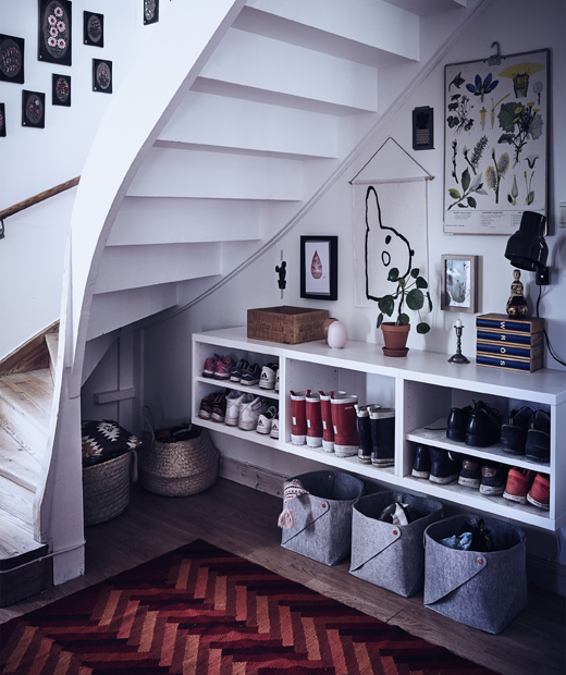 Отворено пространство под стълбище с кошници за съхранение и рафтове за обувки.